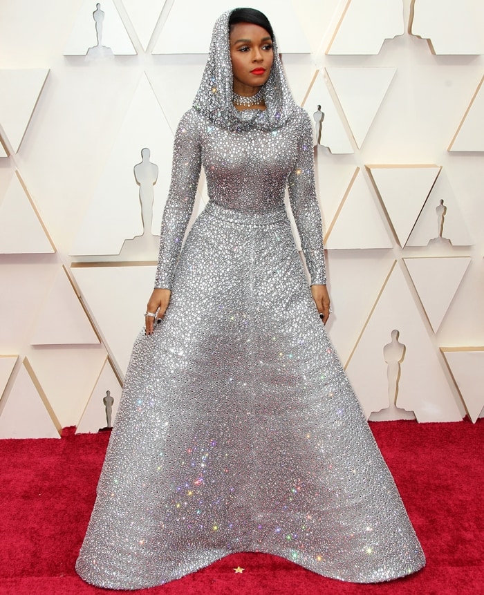 Janelle Monáe commands the red carpet in a sweeping, hooded Ralph Lauren gown encrusted with over 168,000 Swarovski crystals, its sculpted silhouette shimmering with every step at the Academy Awards