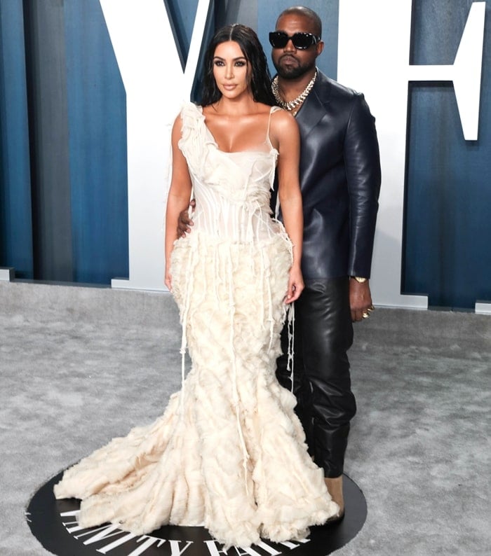 Kim Kardashian posing with her husband Kanye West at the 2020 Vanity Fair Oscar Party