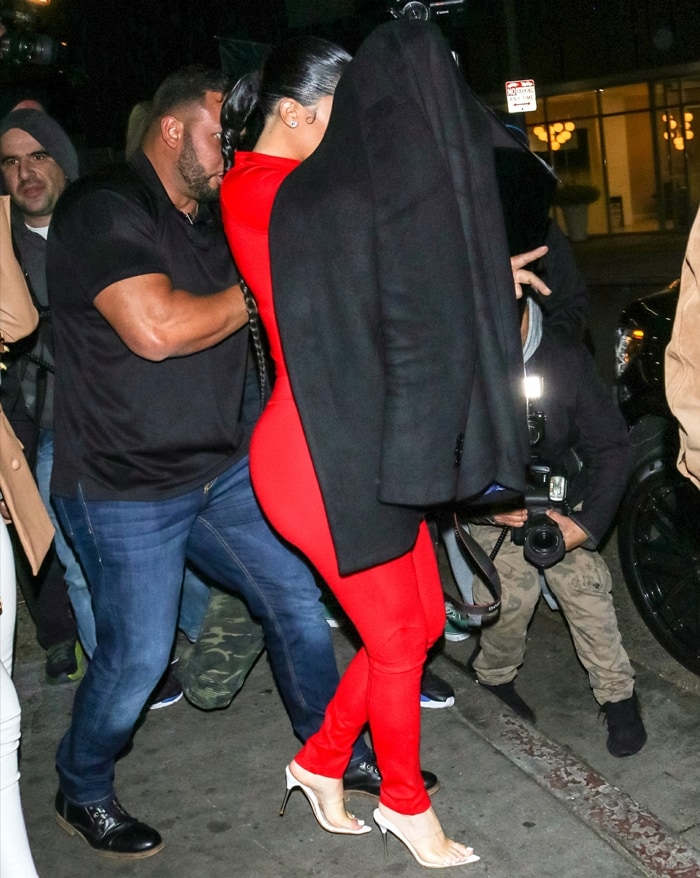 Kylie Jenner leaves The Nice Guy in West Hollywood wearing a striking monochromatic red ensemble paired with barely-there nude mule heels and a Judith Leiber lip-shaped clutch on February 12, 2020