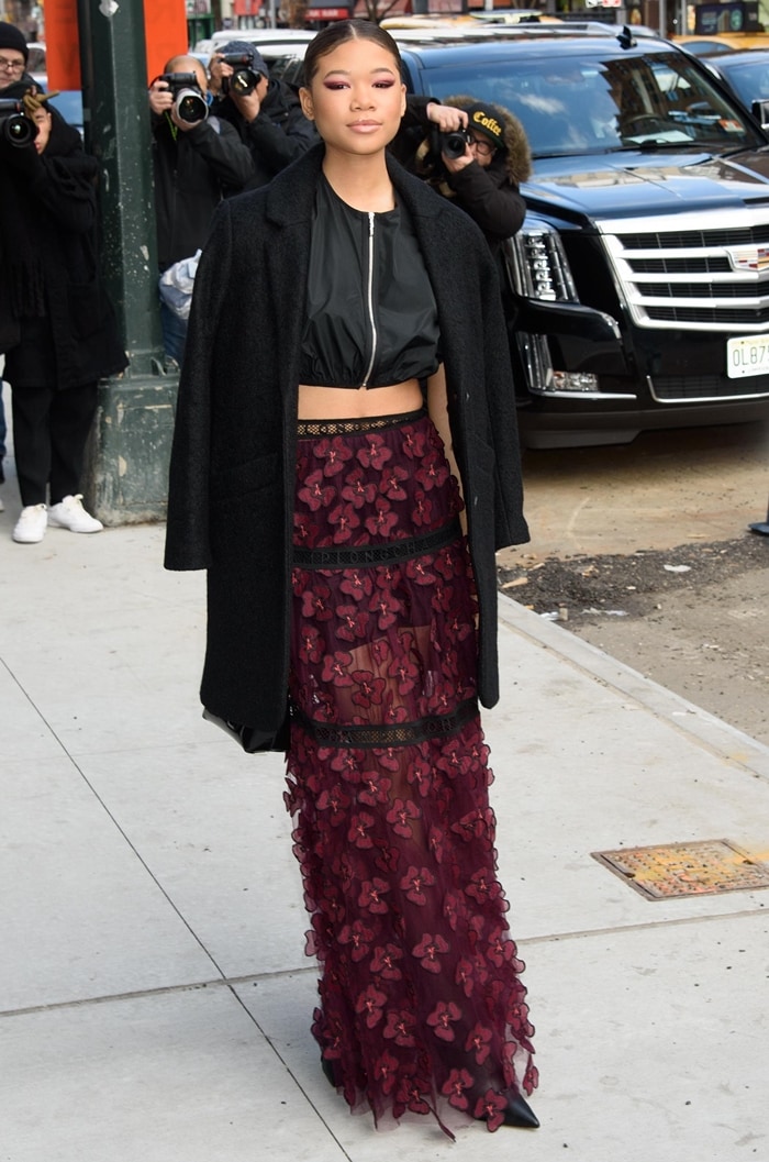 Storm Reid steps out in a cropped bomber jacket, burgundy floral-embroidered maxi skirt, and long black coat at the Longchamp Fall/Winter 2020 show in New York City
