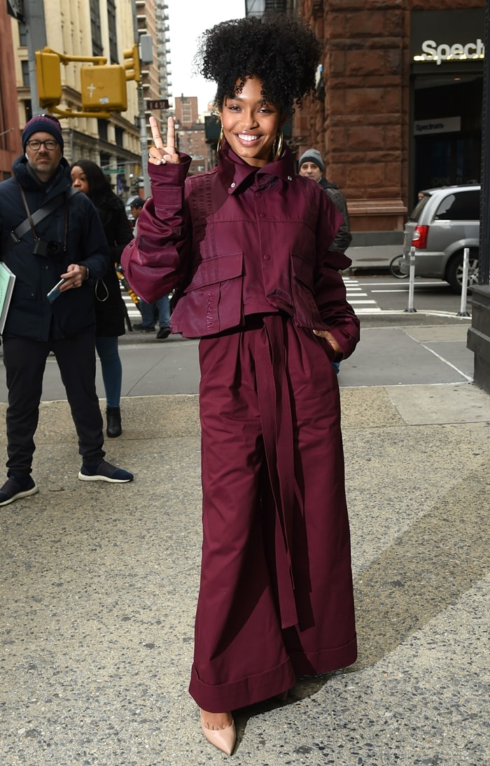 Yara Shahidi rocked a bold burgundy outfit from the Adidas x Ivy Park capsule collection while flashing a peace sign outside the Build Studio in New York City on January 14, 2020