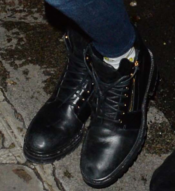 Cara Delevingne grounded her off-duty Paris look with chunky black lace-up combat boots that added a utilitarian edge to her cropped top and high-waisted jeans ensemble