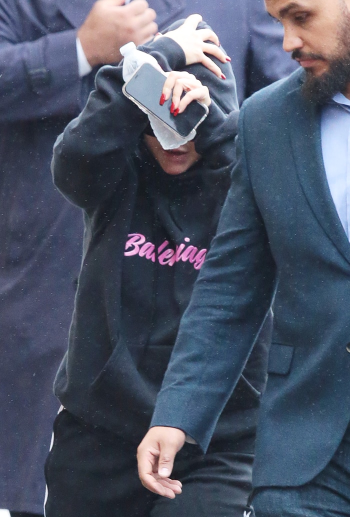 Christina Aguilera shielded her face beneath a black Balenciaga hoodie accented with bright pink lettering while heading into the studio