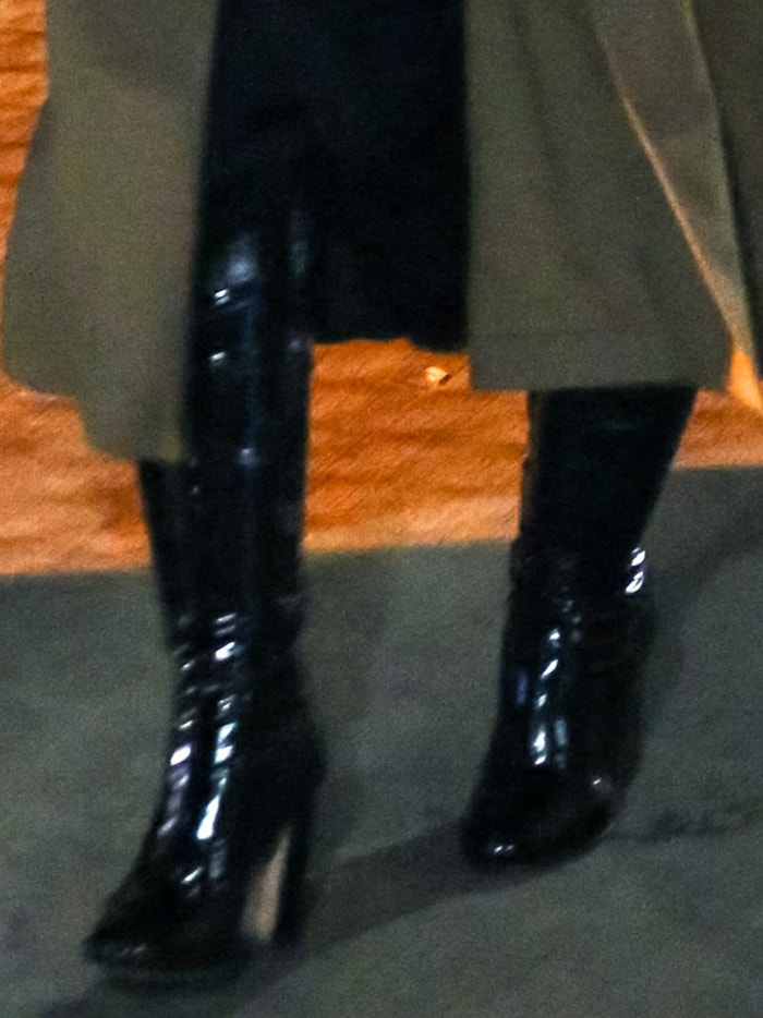Her black patent boots added a sharp, liquid-shine finish to the otherwise soft draping of the satin slipdress and oversized coat