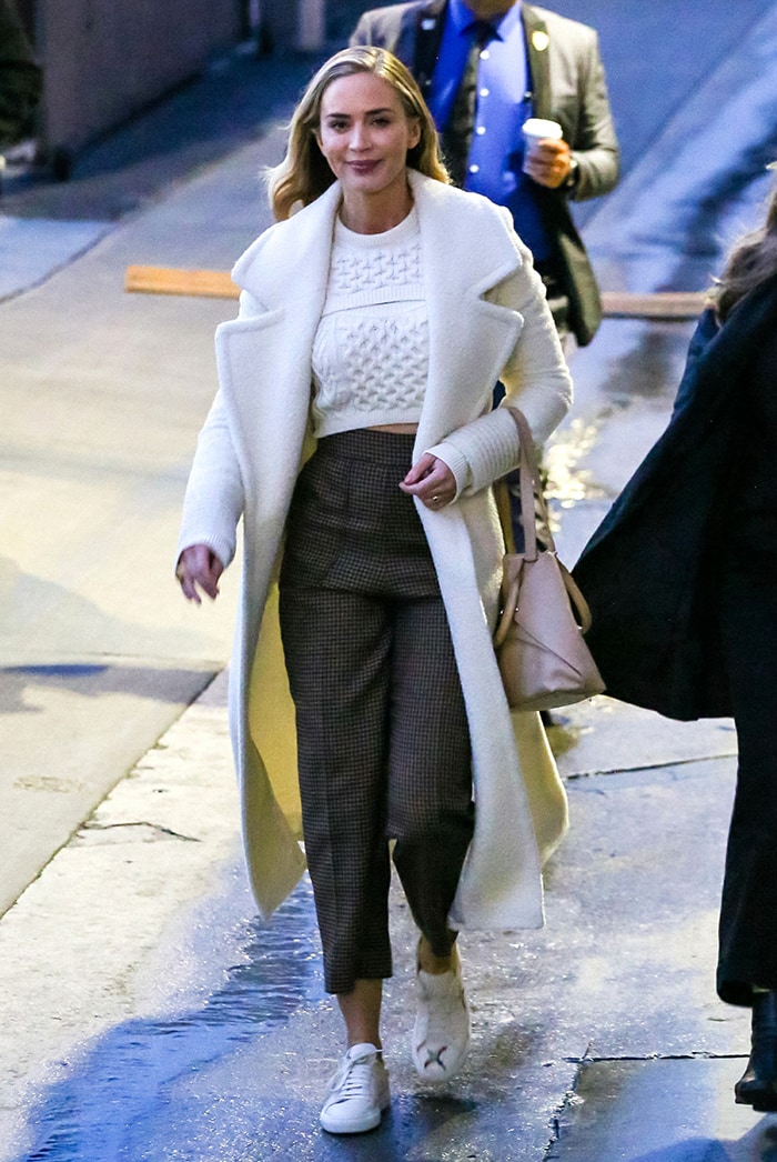 Later the same day, Emily Blunt stepped out in a Rosie Assoulin cropped knit sweater and an ivory Sentaler wrap coat, once again relying on her white Axel Arigato Clean Bird sneakers to bring a relaxed, contemporary edge to the polished look