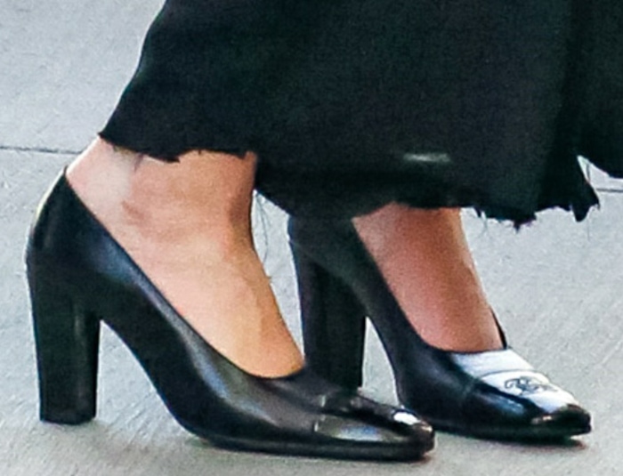 A closer look at Grace VanderWaal’s classic black Chanel pumps, featuring glossy patent leather, a square toe, and sturdy block heels accented with the brand’s signature CC logo