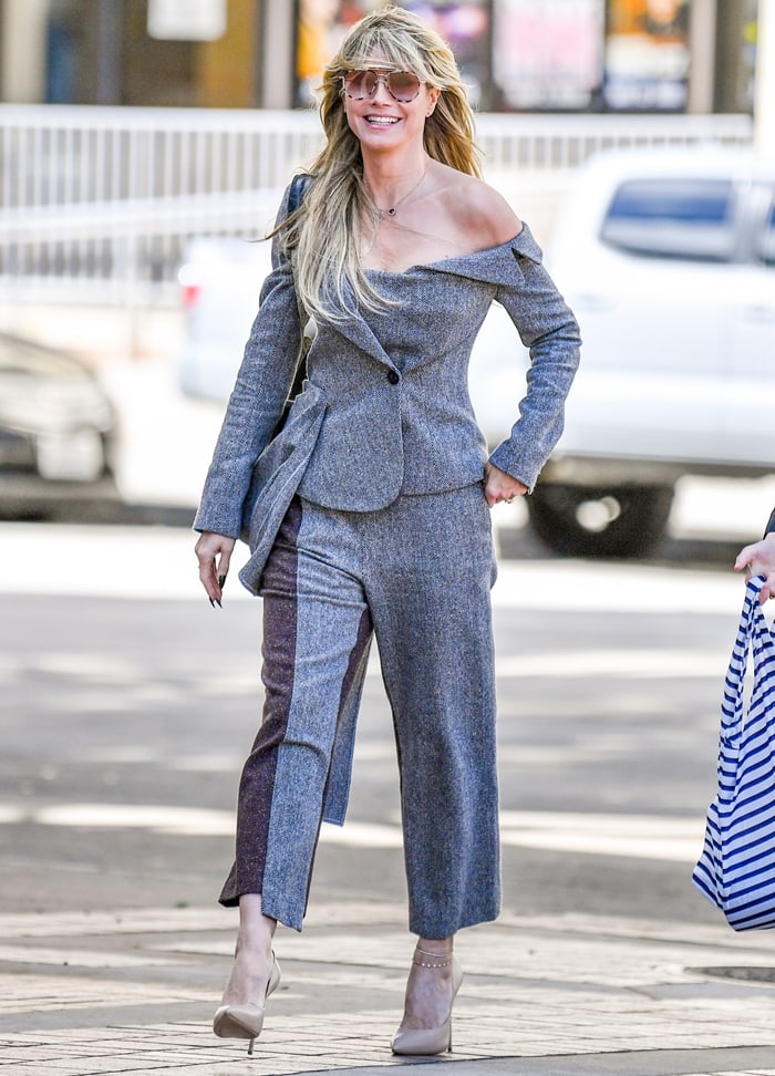 Cropped uneven trouser hems highlight Heidi Klum’s pointed nude pumps and delicate gold anklet as she strides through Los Angeles