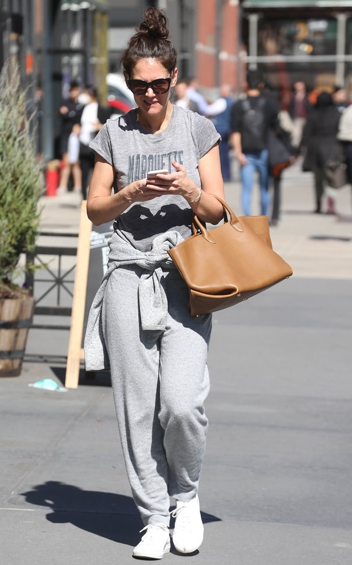 Katie Holmes pairs relaxed Ven Store track pants with visibly broken-in white Common Projects Original Achilles sneakers after a SoulCycle class