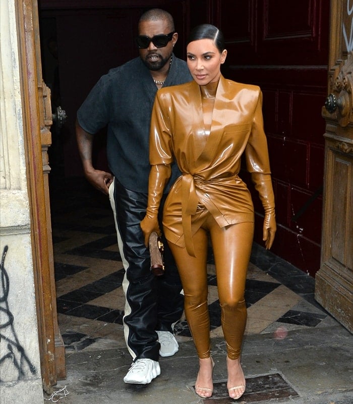 Kanye West keeps it understated in a charcoal gray T-shirt and black leather joggers, letting his futuristic adidas Yeezy 451 prototype—later refined into the Yeezy 450—take center stage as he leaves Sunday Service with Kim Kardashian during Paris Fashion Week