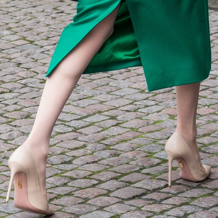 Meghan Markle’s nude Aquazzura pumps elongated her silhouette with their sharply pointed toes, low-cut vamp, and barely-there neutral leather finish peeking out beneath the emerald green midi dress