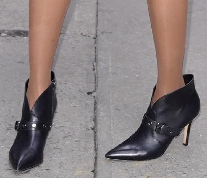 Tyra Banks wearing black Nine West Jax pointed-toe ankle booties with buckle straps and stiletto heels