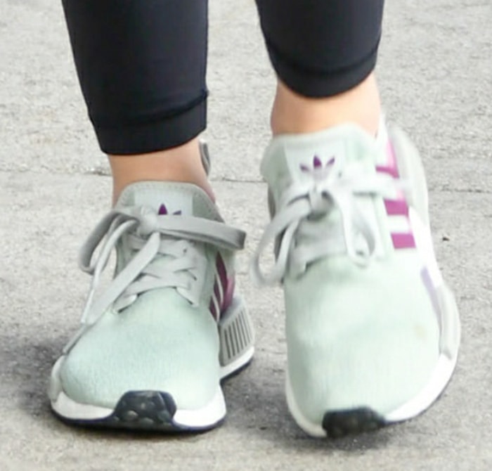 Lucy Hale steps out in Adidas Originals NMD R1 sneakers in Ash Silver, letting the soft pastel colorway and streamlined silhouette anchor her polished, gym-ready athleisure look