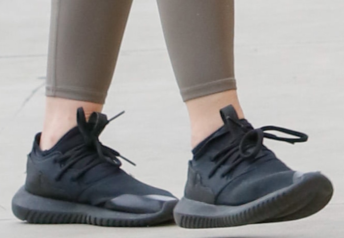 Lucy Hale finishes her streamlined athleisure look with black Adidas Originals Tubular Entrap sneakers, whose sculptural sole adds a sleek, fashion-forward edge to her post-gym outfit