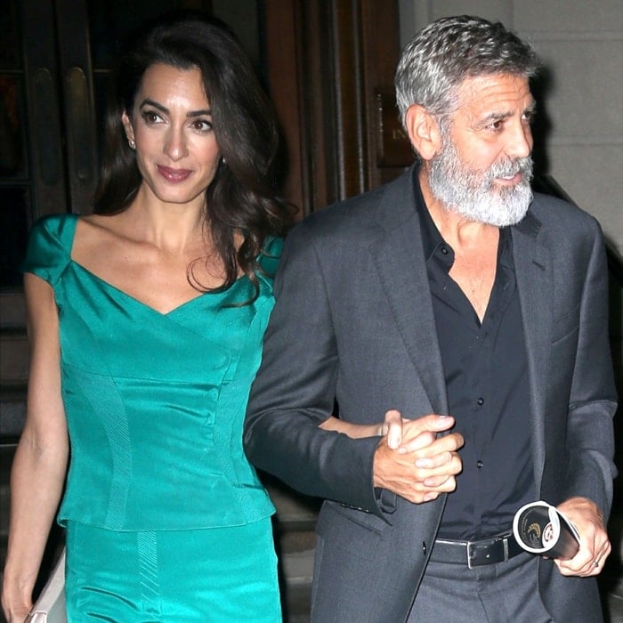 Amal Clooney looks stunning in an elegant teal dress while holding hands with George Clooney