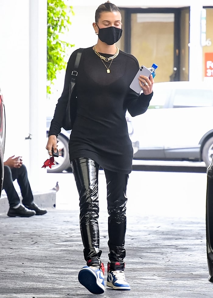 Hailey Bieber’s sleek black tunic and vinyl-finish pants allowed the reconstructed Union Los Angeles x Air Jordan 1s to dominate the outfit with their exposed stitching and split-color blocking