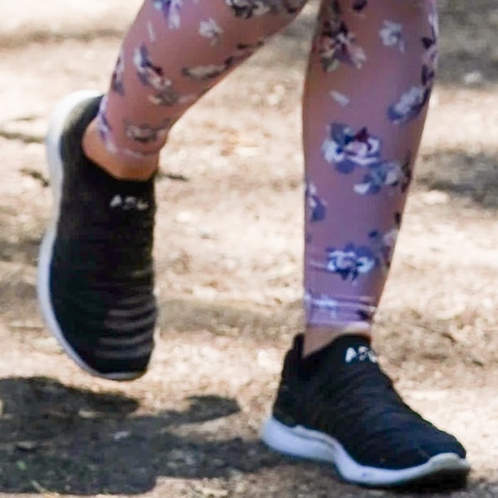 A close-up of Lucy Hale's black-and-white APL TechLoom Wave sneakers highlights the breathable knit upper and streamlined silhouette that made the performance style a celebrity favorite for daily walks and workouts