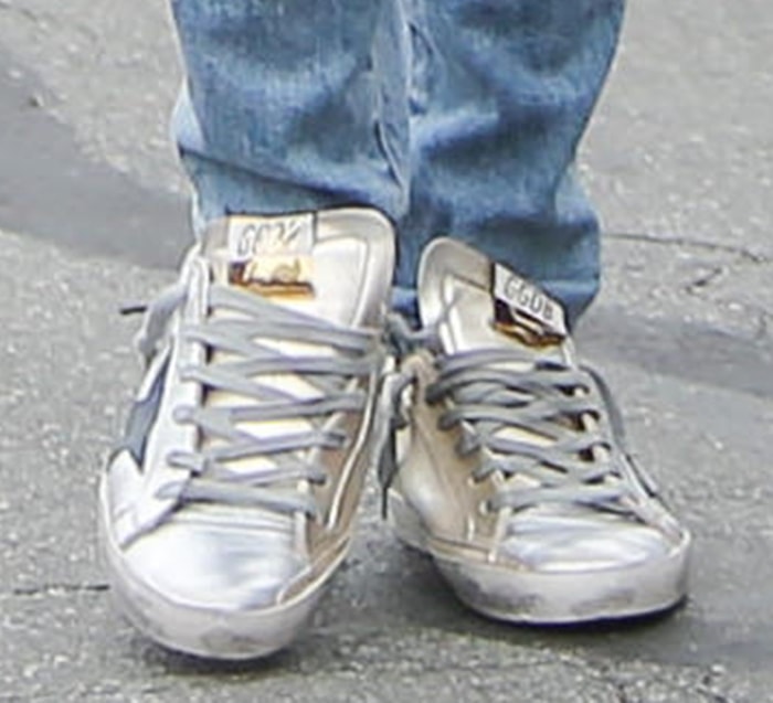 Ana de Armas finishes her double-denim outfit with metallic-accent Golden Goose Superstar sneakers, the brand's signature distressed leather style known for its worn-in look and star-shaped side panel