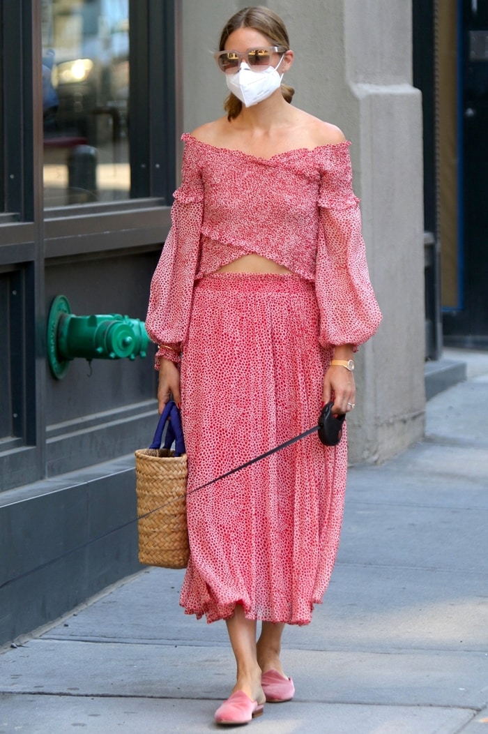 The pleated midi skirt and puff-sleeve crop top create a coordinated summer look, while Palermo’s flat pink mules keep the outfit practical for a New York City walk