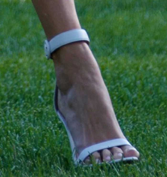 Ivanka Trump completed her look with white Gianvito Rossi Portofino sandals featuring slim ankle straps, signature round buckles, and sleek stiletto heels