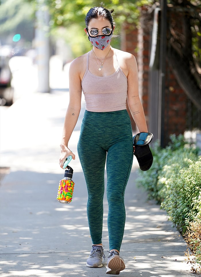 Lucy Hale stepping out for a hike in Los Angeles on July 27, 2020, wearing gray Nike Air Zoom Pegasus 36 sneakers with green Outdoor Voices leggings and a blush Beyond Yoga cropped tank for a streamlined off-duty workout look