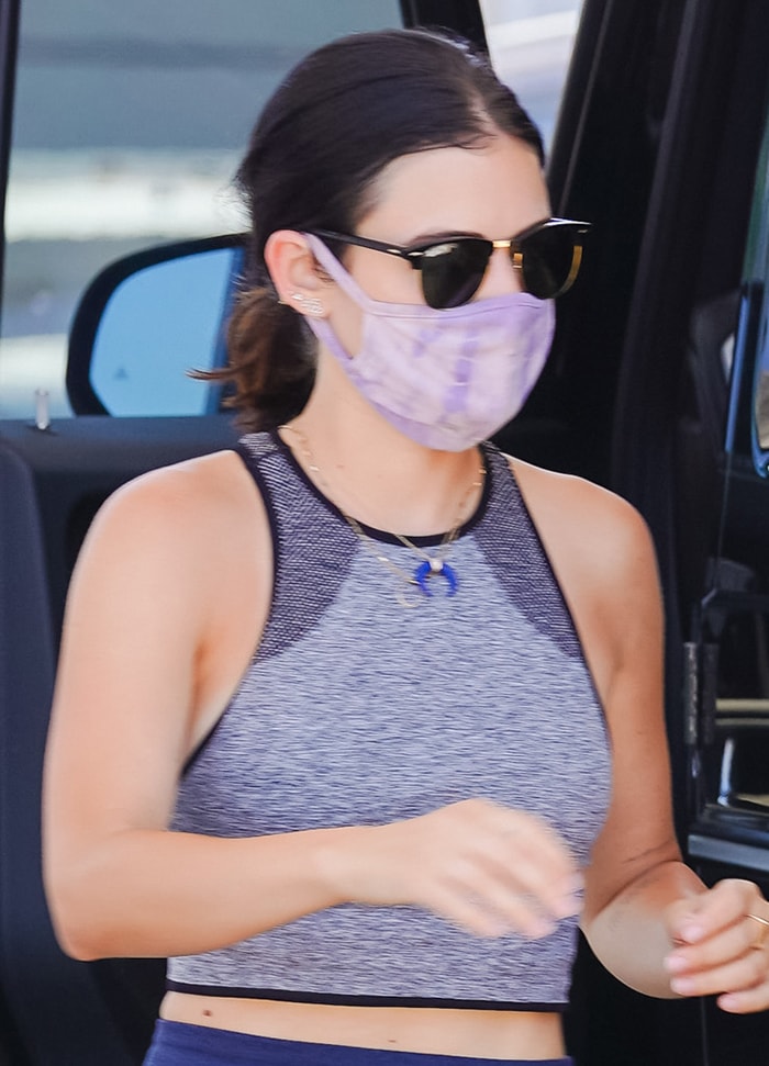 Lucy Hale adds a soft pop of color to her sporty look with a lavender Nikxie tie-dye face mask, finishing the off-duty ensemble with classic Ray-Ban Clubmaster sunglasses and minimal gold jewelry