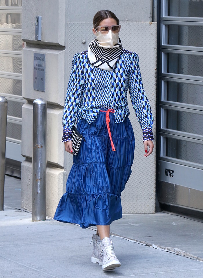 Olivia Palermo wears a patterned blue blouse, Max Co. midi skirt, and Roger Vivier Viv Rangers boots
