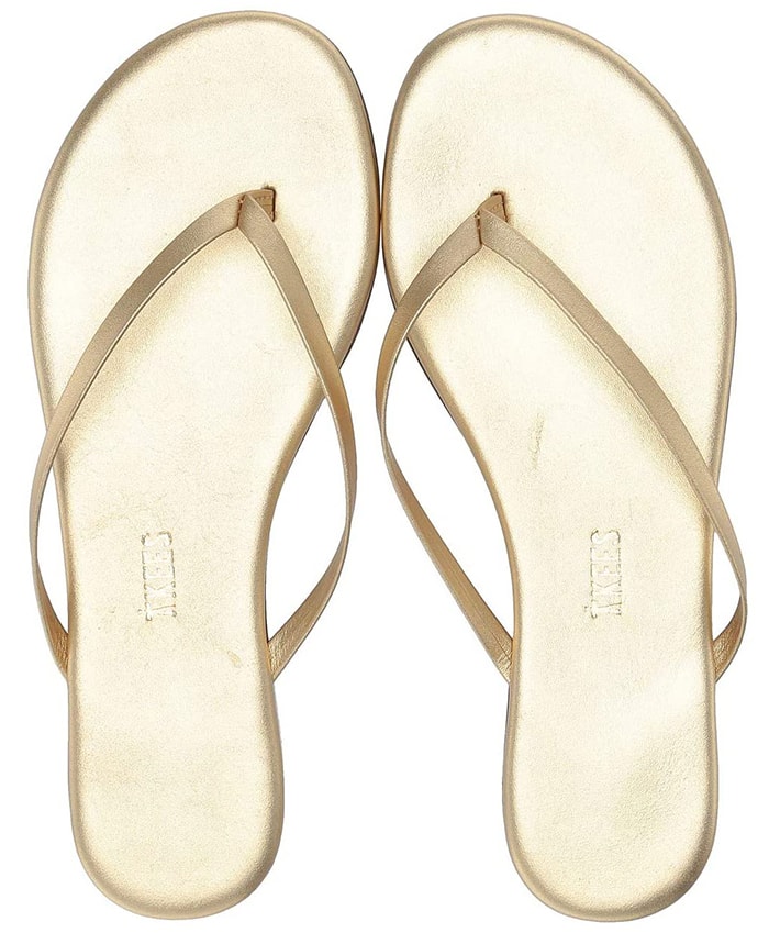 The Tkees "Highlighter" flip-flops in metallic gold feature the brand's signature minimalist leather thong design with a softly cushioned footbed