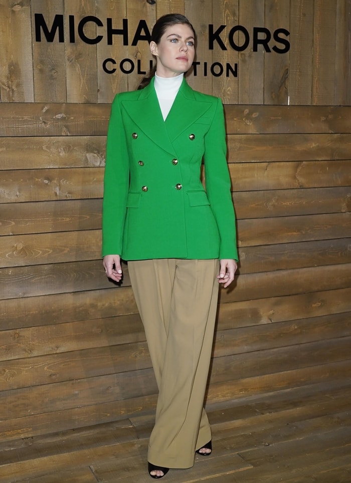 Alexandra Daddario exudes sophistication in a bold green double-breasted blazer paired with neutral wide-leg trousers