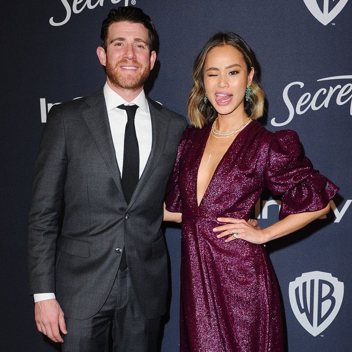 Jamie Chung wows in a sparkling purple gown with puffed sleeves and a deep V-neckline while posing alongside her husband, Bryan Greenberg, at the 2020 InStyle and Warner Bros. Golden Globe Awards After-Party