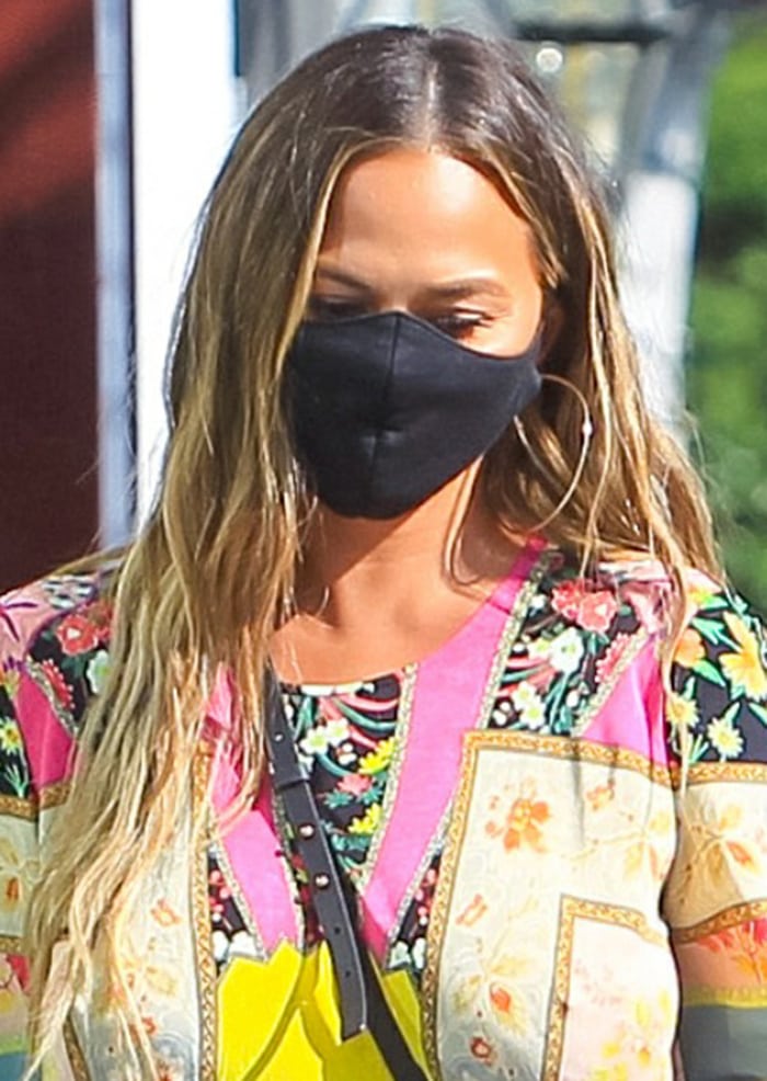 Large silver hoops, sun-lightened waves, and a black face mask gave Chrissy’s dramatic bohemian look a laid-back West Hollywood feel