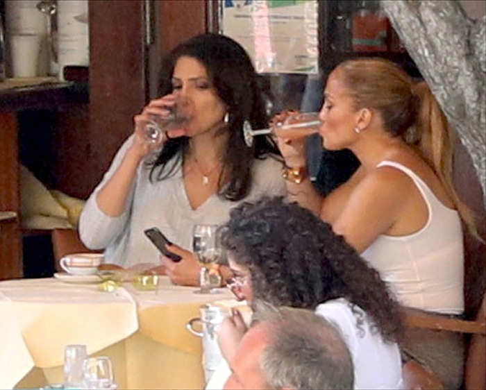Lynda Lopez keeps it casual in a light blue knit sweater, while Jennifer Lopez stuns in a fitted white bodysuit that shows off her toned arms and curves