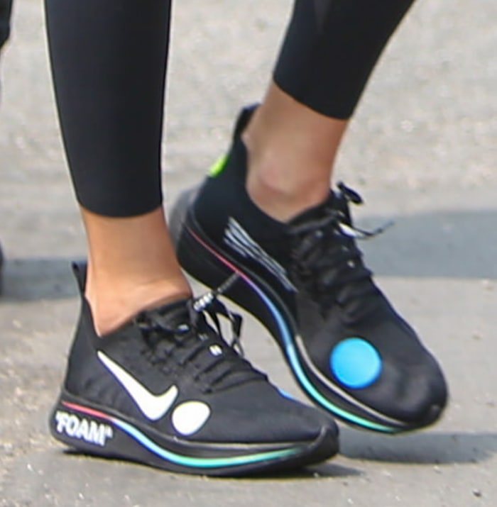 Kendall Jenner grounded her sporty athleisure look with rare Off-White x Nike Zoom Fly Mercurial sneakers, featuring Virgil Abloh’s signature oversized graphic dots, rainbow-trimmed soles, and football-inspired Flyknit construction