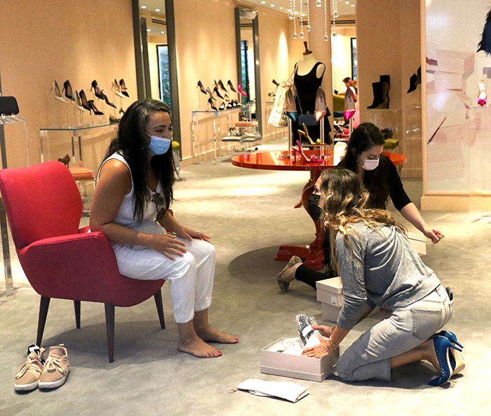 Sarah Jessica Parker helps a customer try on a pair of shoes from her collection