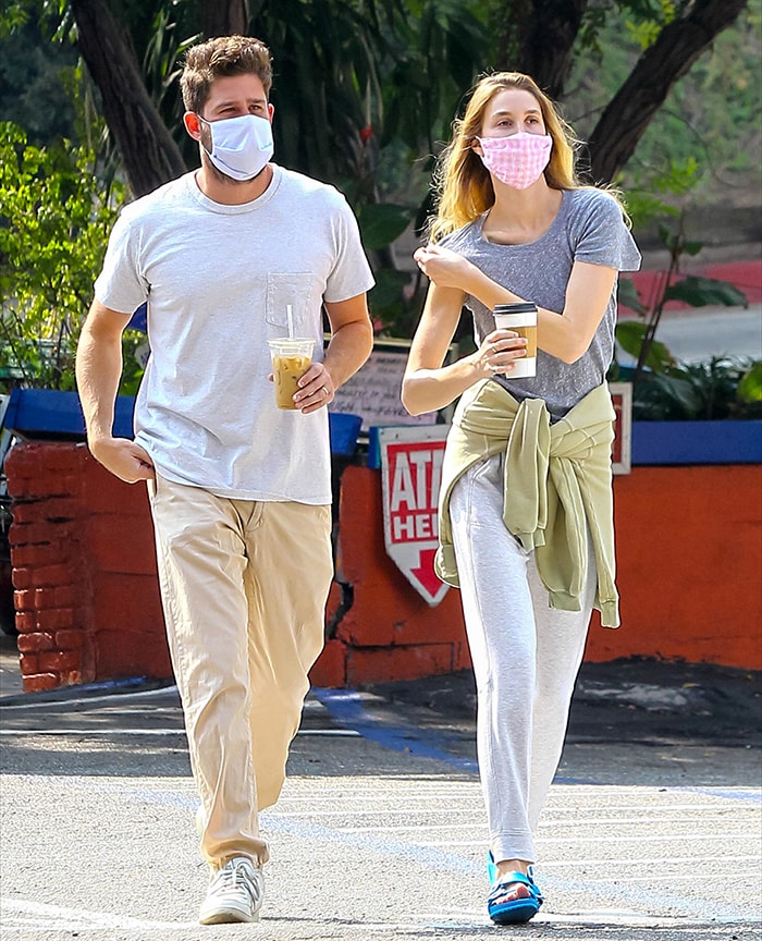 Tim Rosenman wears a white T-shirt, khaki pants, and white sneakers alongside Whitney Port in blue Birkenstock sandals