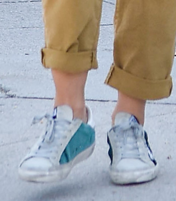 Lucy Hale completes her off-duty outfit with distressed white Golden Goose low-top sneakers featuring contrasting teal and black heel tabs