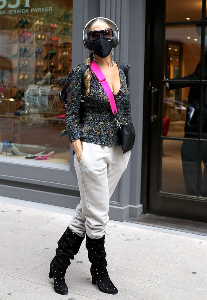 Sarah Jessica Parker arrives at her SJP by Sarah Jessica Parker boutique in Midtown Manhattan on October 7, 2020, pairing relaxed sweatpants with studded black “Busker” knee-high boots from her collection for a chic, shoe-first take on off-duty style