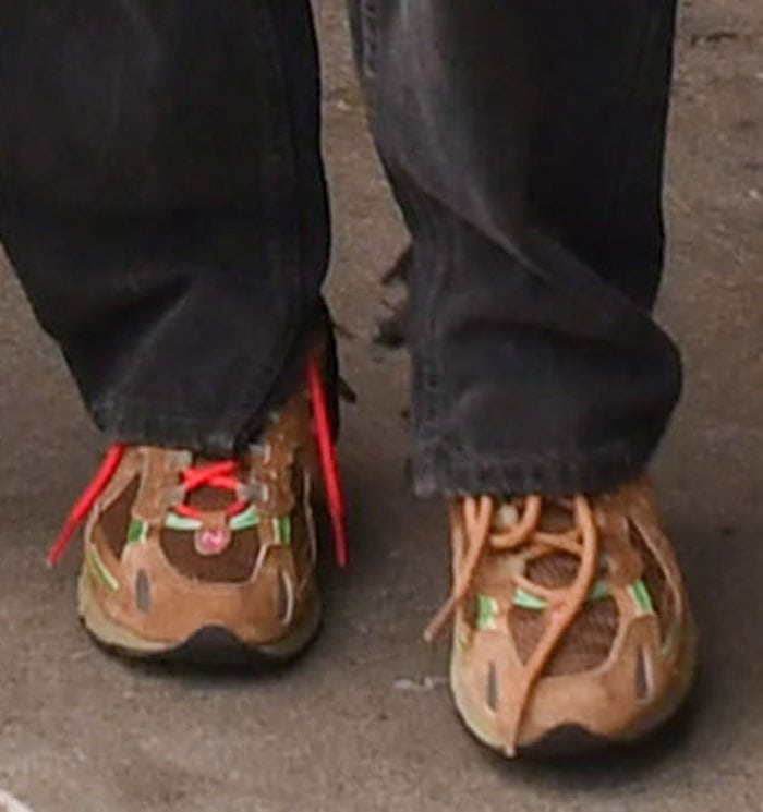A closer look at Bella Hadid’s New Balance x Stray Rats 827 “Sewer Stompers,” featuring a muddy brown mixed-material upper, neon-green accents, contrasting laces, and ABZORB cushioning