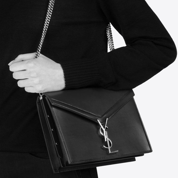 This Cassandra monogram clasp bag is crafted from calf leather and features an envelope style, a foldover top with snap closure, antique effect gold-tone hardware, a chain strap, an internal zipped pocket, two interior compartments, and a front slip pocket