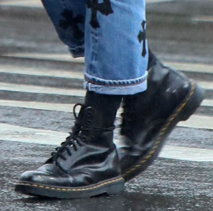 Irina Shayk adds an edgy touch to her rainy-day ensemble with classic Dr. Martens 1460 boots, effortlessly blending style and practicality on the streets of NYC