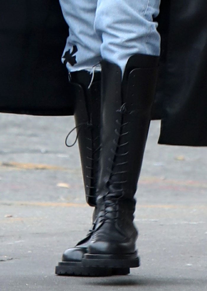 Irina Shayk elevates her grungy, androgynous aesthetic with statement-making Magda Butrym knee-high lace-up boots, adding an effortlessly bold edge to her look