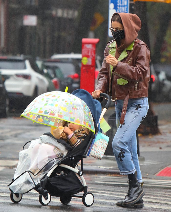 Irina Shayk steps with daughter Lea De Seine for a rainy morning stroll in New York City on November 13, 2020, effortlessly blending style and practicality with Dmy by Dmy Olsen sunglasses, a Jennifer Meyer diamond cross necklace, and a Babyzen Yoyo+ stroller for a chic mom-on-the-go look