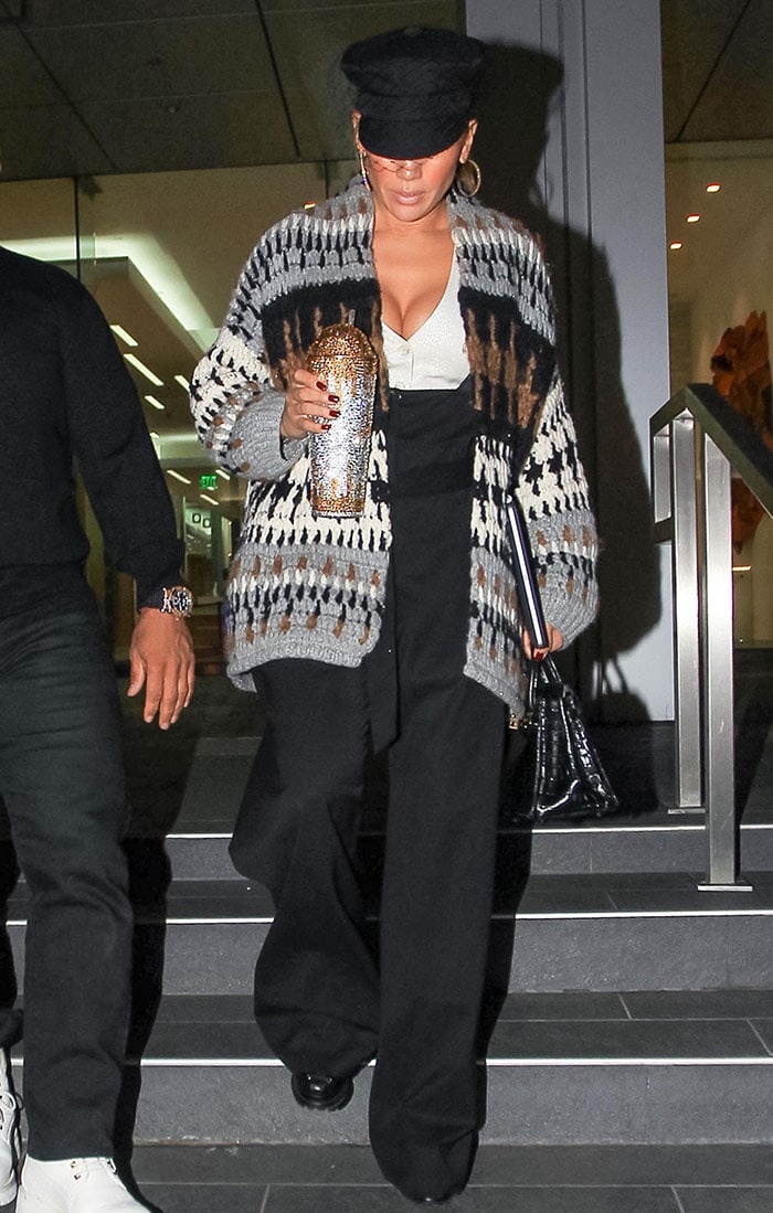 Jennifer Lopez leaves Soho House West Hollywood in a cozy-chic look, pairing wide-leg Brunello Cucinelli pants with a plunging top, knit cardigan, and towering platform boots from her DSW collection