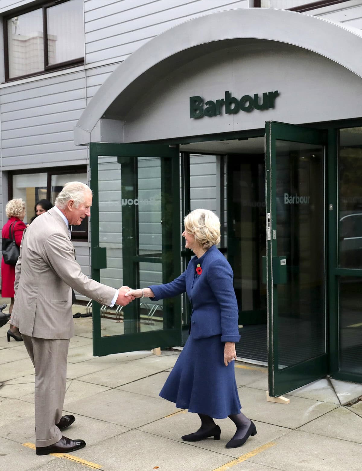 Prince Charles, the Prince of Wales, greets Dame Margaret Barbour during a tour of J. Barbour Sons Ltd. in Tyne and Wear on November 9, 2021, highlighting the brand’s royal heritage and continued excellence in British manufacturing