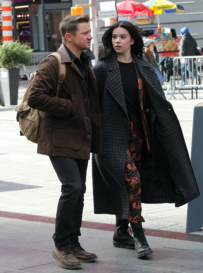 Hailee Steinfeld layers a plaid Proenza Schouler coat over Scotch Soda floral separates and black combat boots while filming Hawkeye with Jeremy Renner in New York City