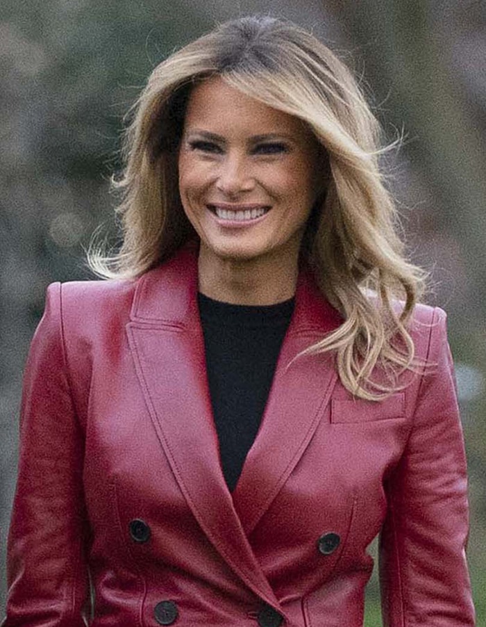 Melania Trump styles her hair in loose waves and wears her signature smoky eye makeup