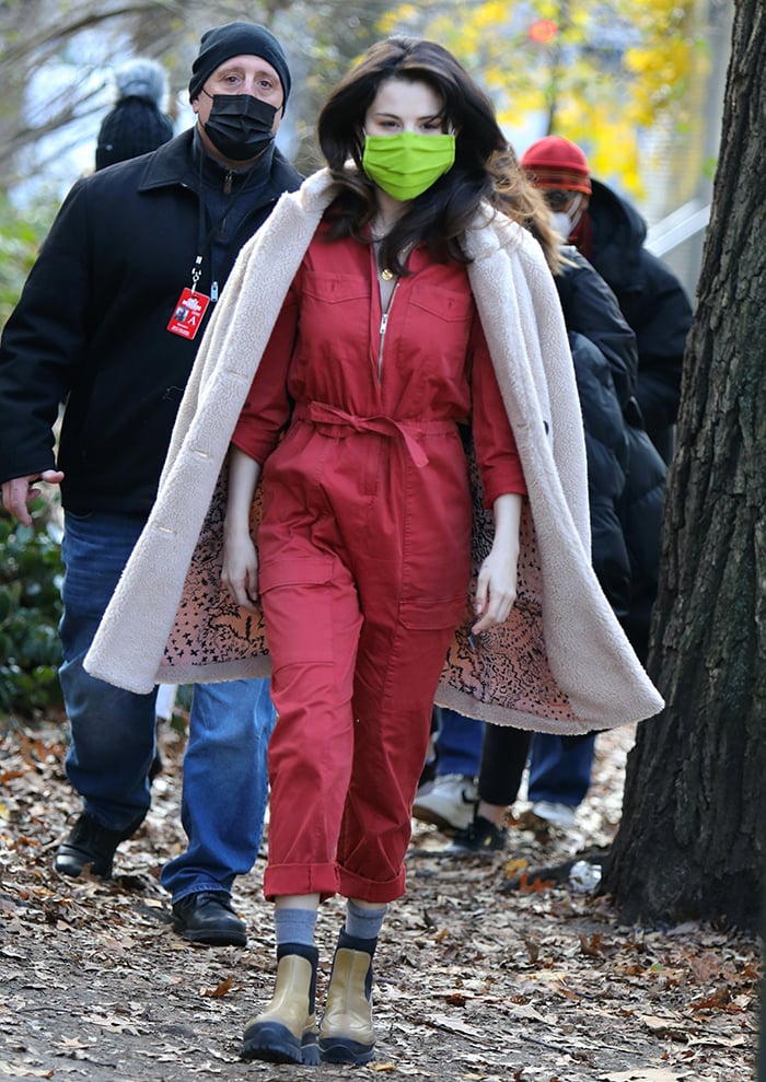Selena Gomez turns heads in a red utility jumpsuit layered with a beige faux-fur coat and mustard Stella McCartney ankle boots while filming “Only Murders in the Building” in New York City on December 8, 2020