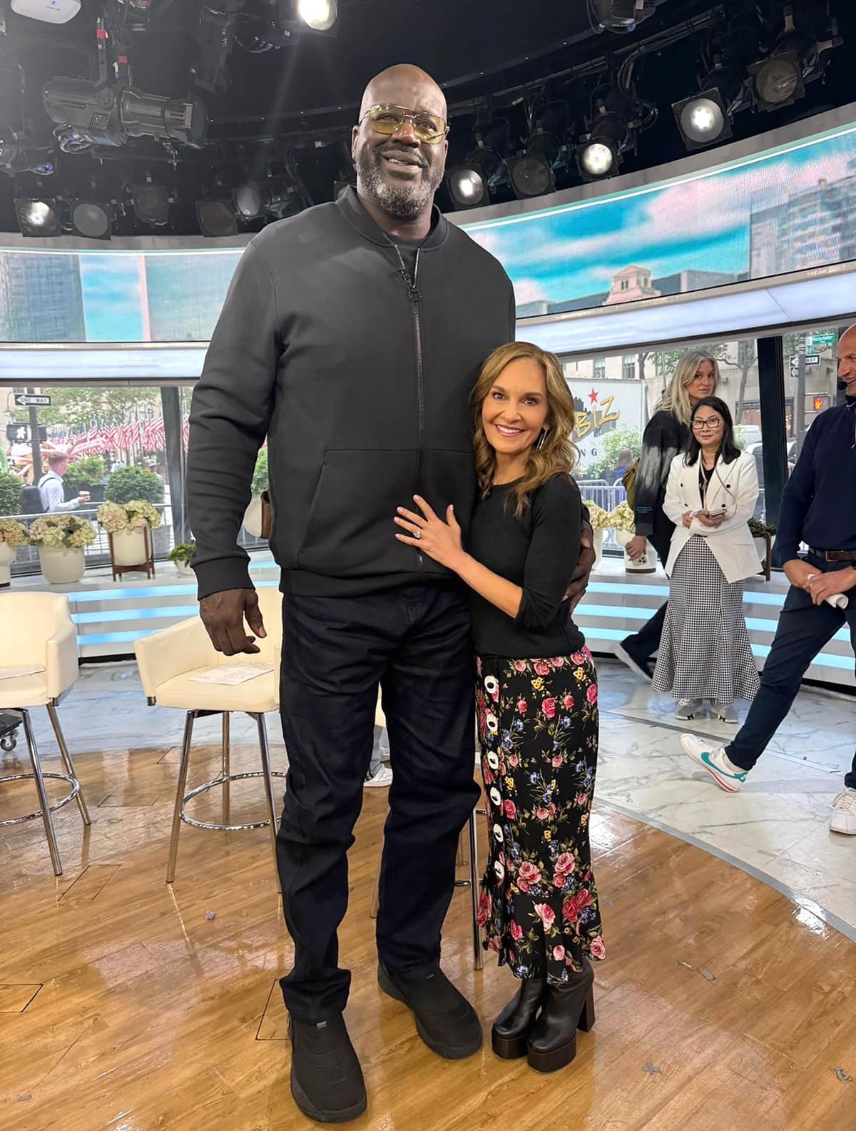 Shaquille O’Neal, standing 7′1″ tall in a black zip-up jacket and jeans, towers over 5′1″ Joy Bauer, who adds a few inches with platform boots and a floral skirt during a commercial break on the Today show