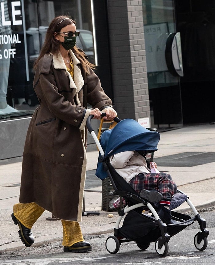 Irina Shayk balances a plush shearling-lined leather coat with textured yellow knitwear, grounding the look in chunky black flatform Chelsea boots as she strolls through New York City with her daughter on January 22, 2021