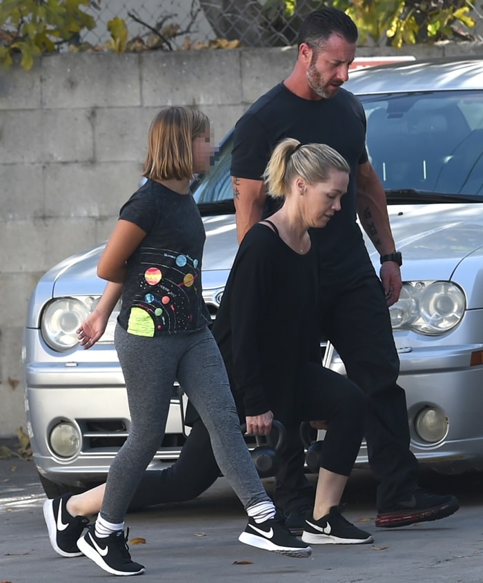 Jennie Garth trains outdoors with her daughter, Fiona Eve Facinelli, both wearing athletic Adidas sneakers while working with a personal trainer
