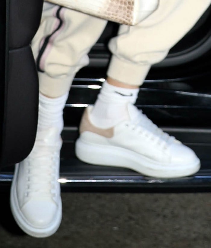 Jennifer Lopez pairs pastel pink-trimmed Alexander McQueen oversized sneakers with white Nike crew socks, completing her relaxed rehearsal outfit